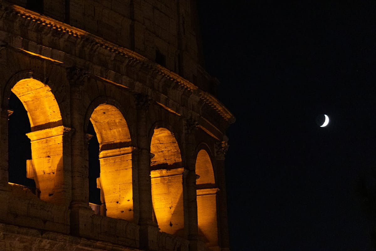 Colosseum in Rome with crescent moon in the night sky