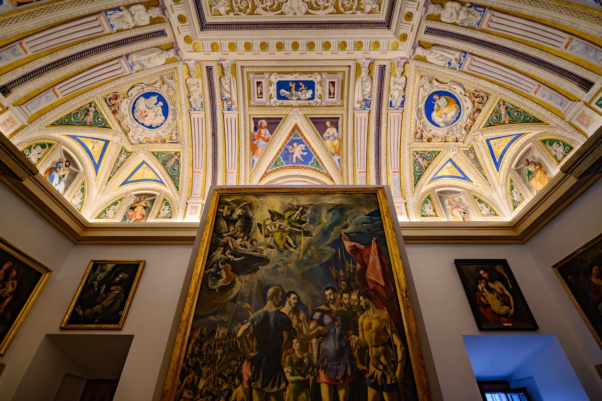 Intricate ceiling and classical paintings in an art museum in Madrid