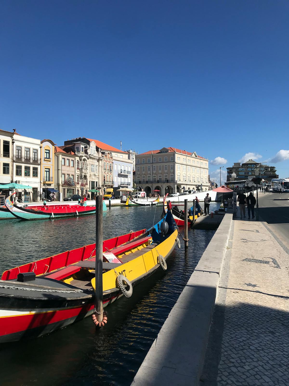 Colorful moliceiro boats lined up along an Aveiro canal on a sunny day