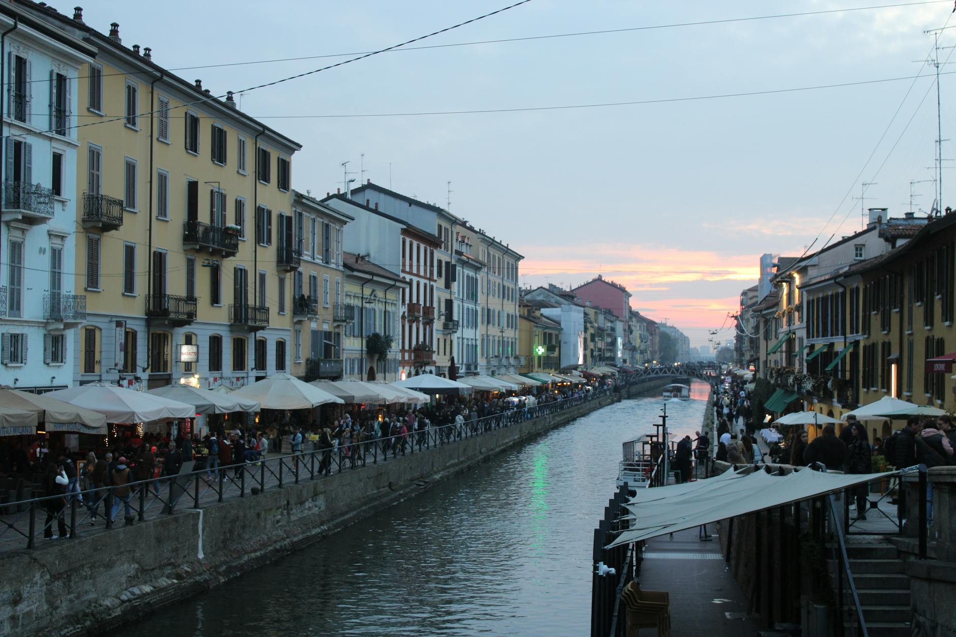 Evening view of Naviglio Grande canal in Milan with lights reflecting on the water