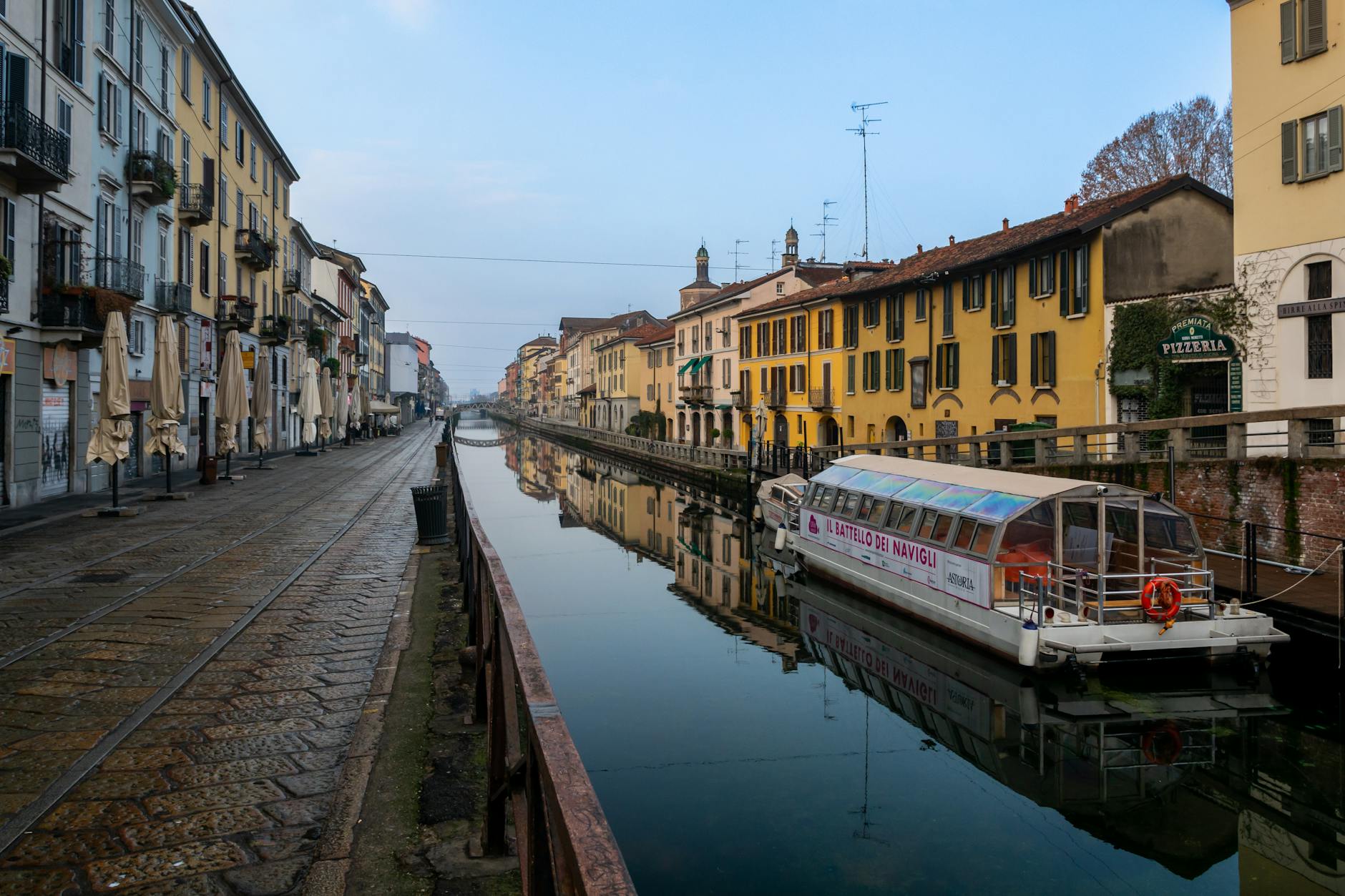 Navigli canal in Milan reflecting historic architecture on a calm day