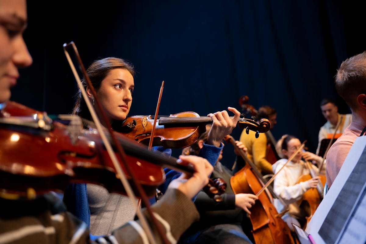 Full symphony orchestra performing on an illuminated concert stage