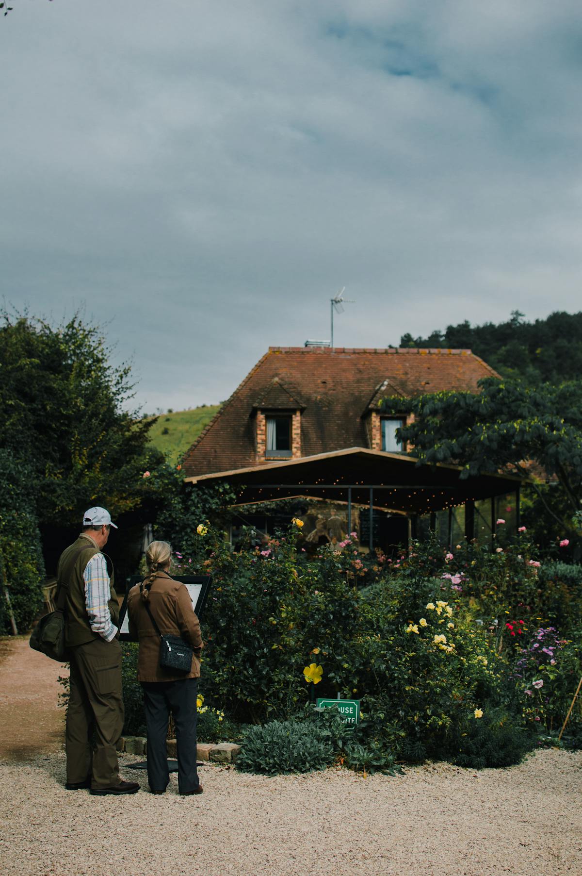 Visitors admire the garden at Giverny with cottage backdrop