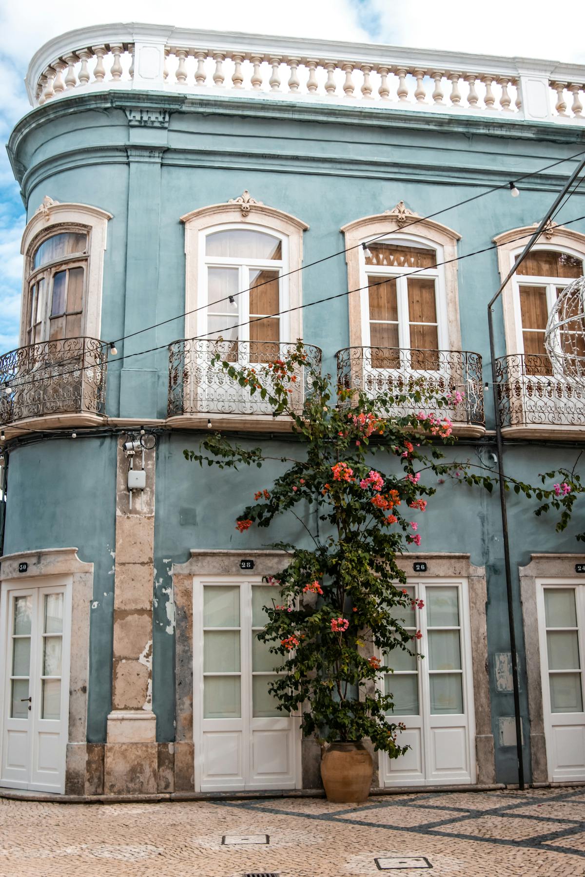 Beautiful historic building with ornate balconies and flowering bougainvillea in Olhao Portugal