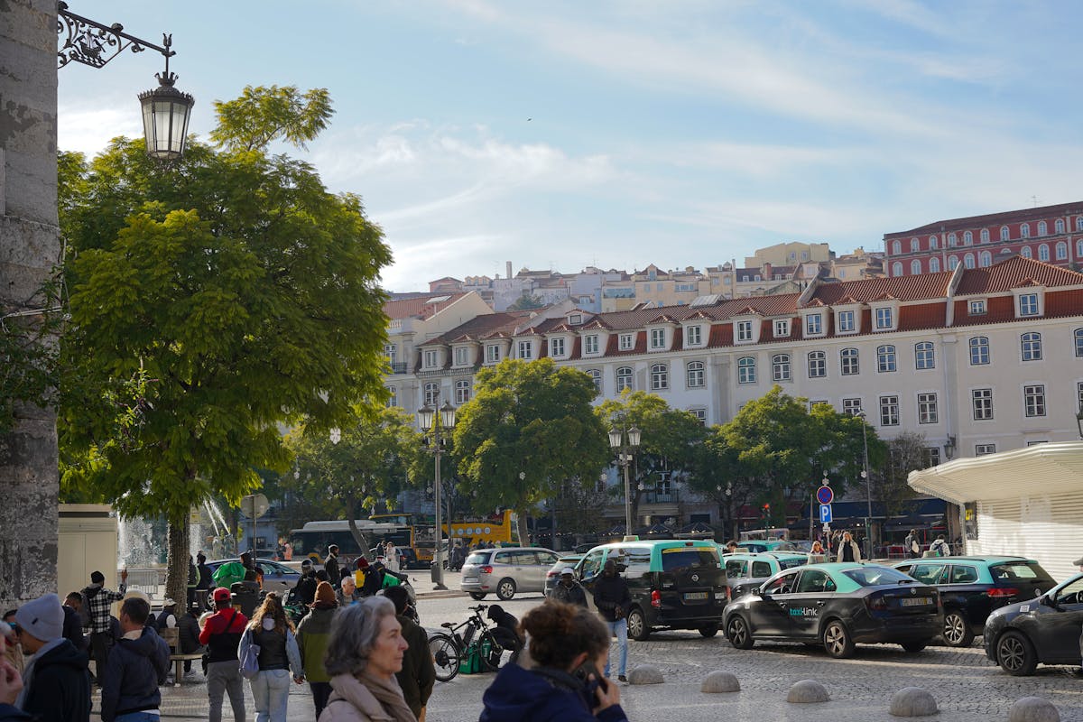 A busy street in Lisbon with classic European architecture and pedestrians