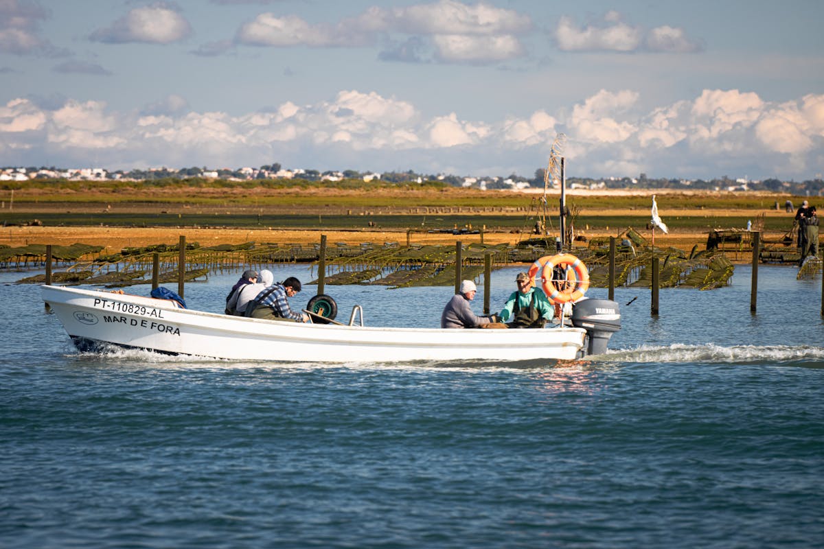 Fishermen on a traditional boat in the Ria Formosa lagoon near Olhao Portugal