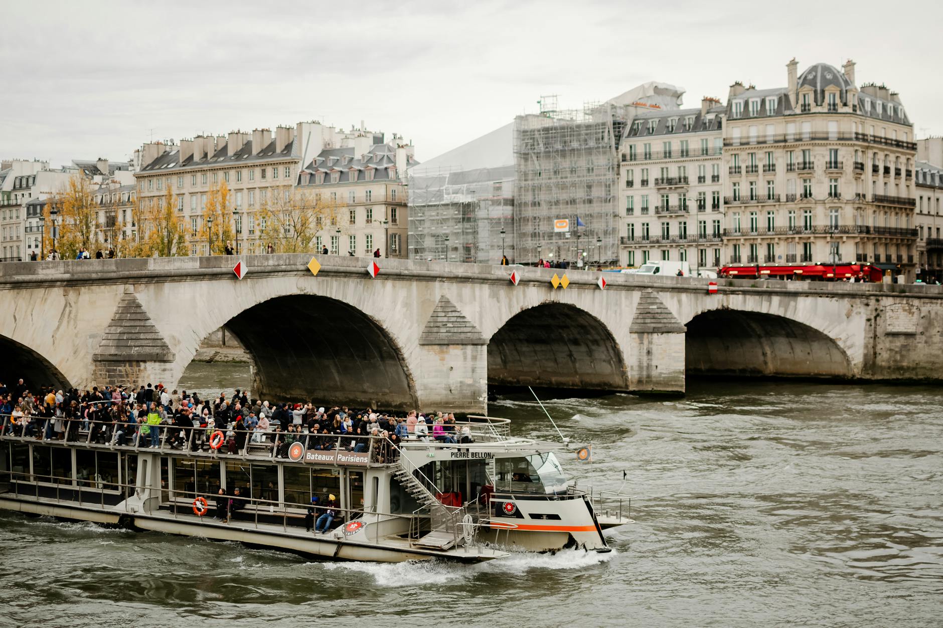 A tour boat passing under a Paris bridge on the Seine