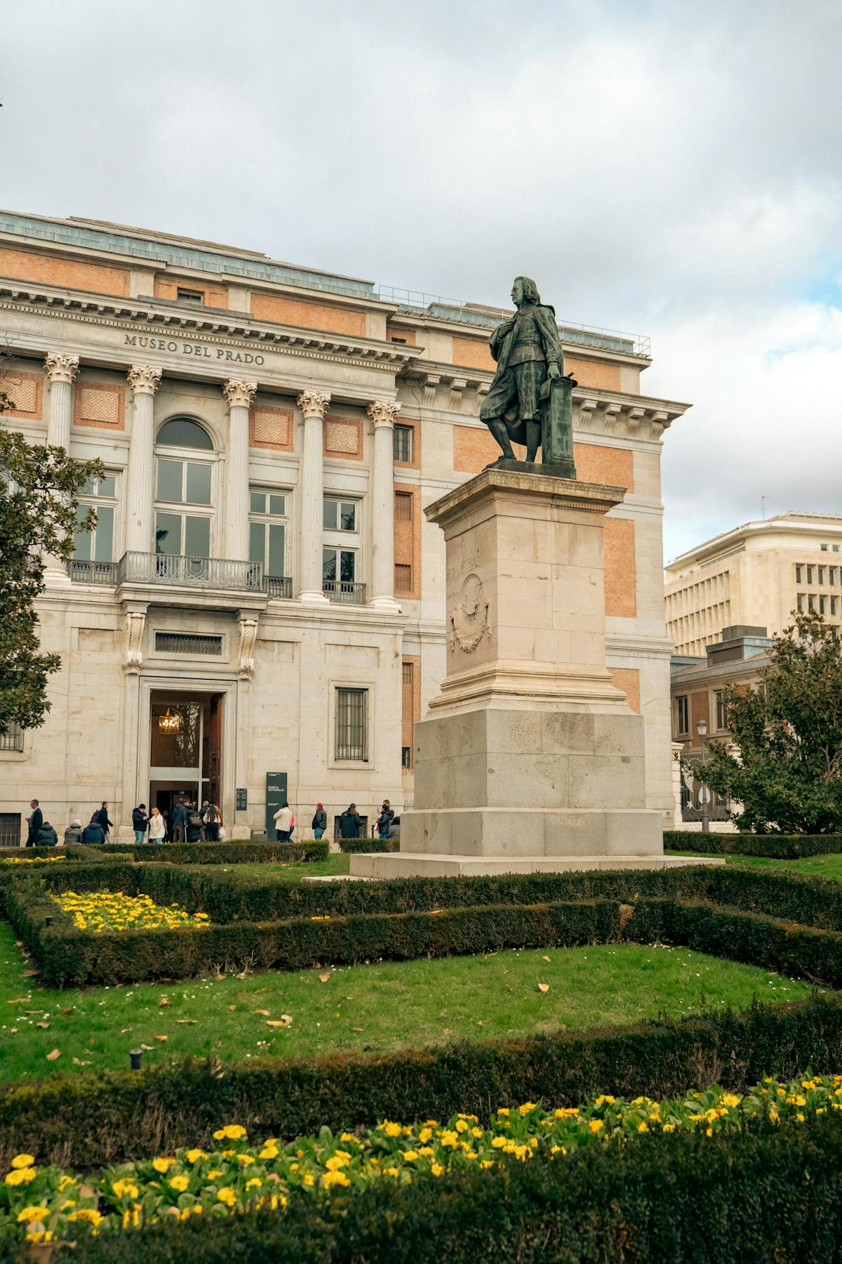 Statue in front of the Museo del Prado facade in Madrid on a clear day
