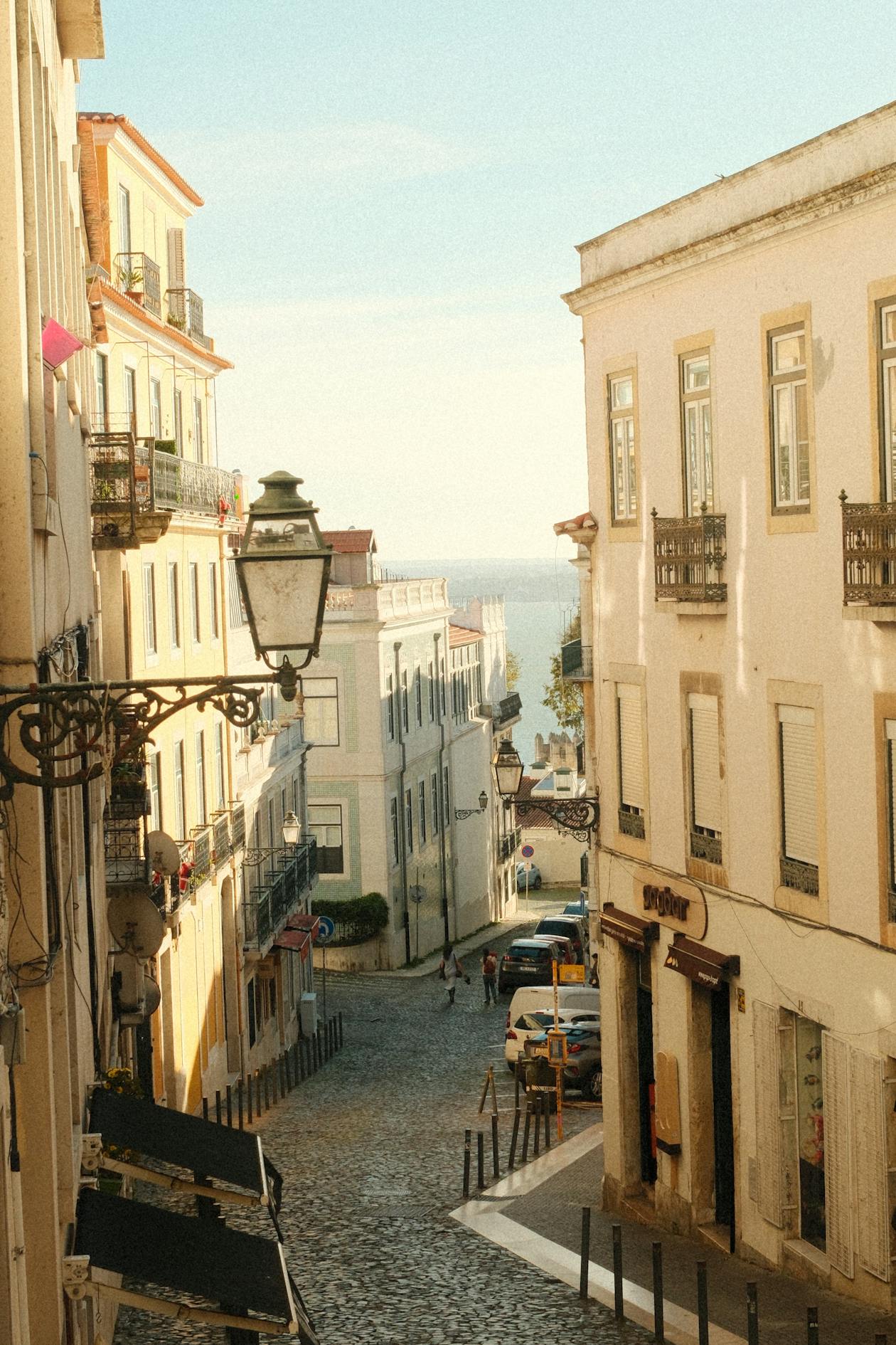 Sunlit cobblestone street with traditional Portuguese architecture in Lisbon