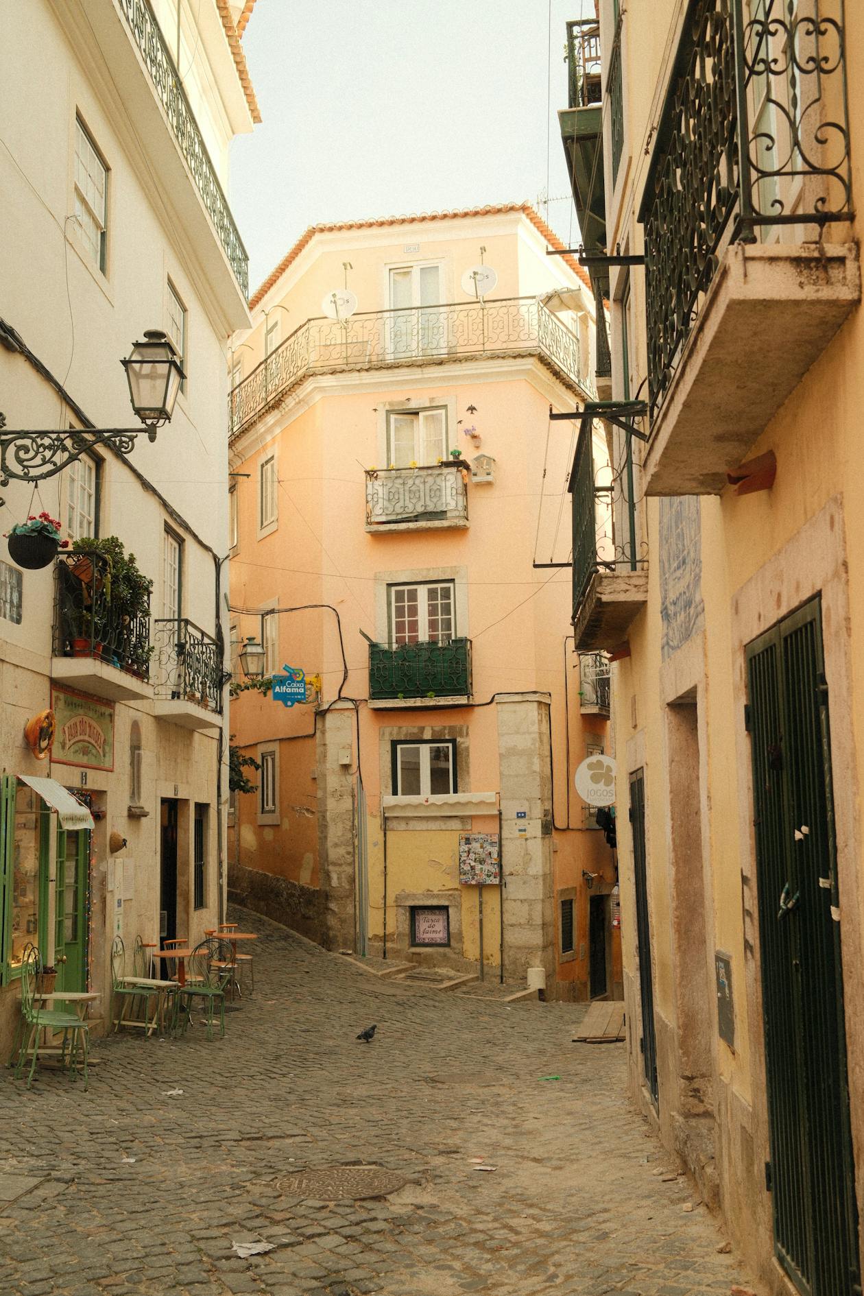 Narrow alleyway in Lisbons historic Alfama district with traditional architecture