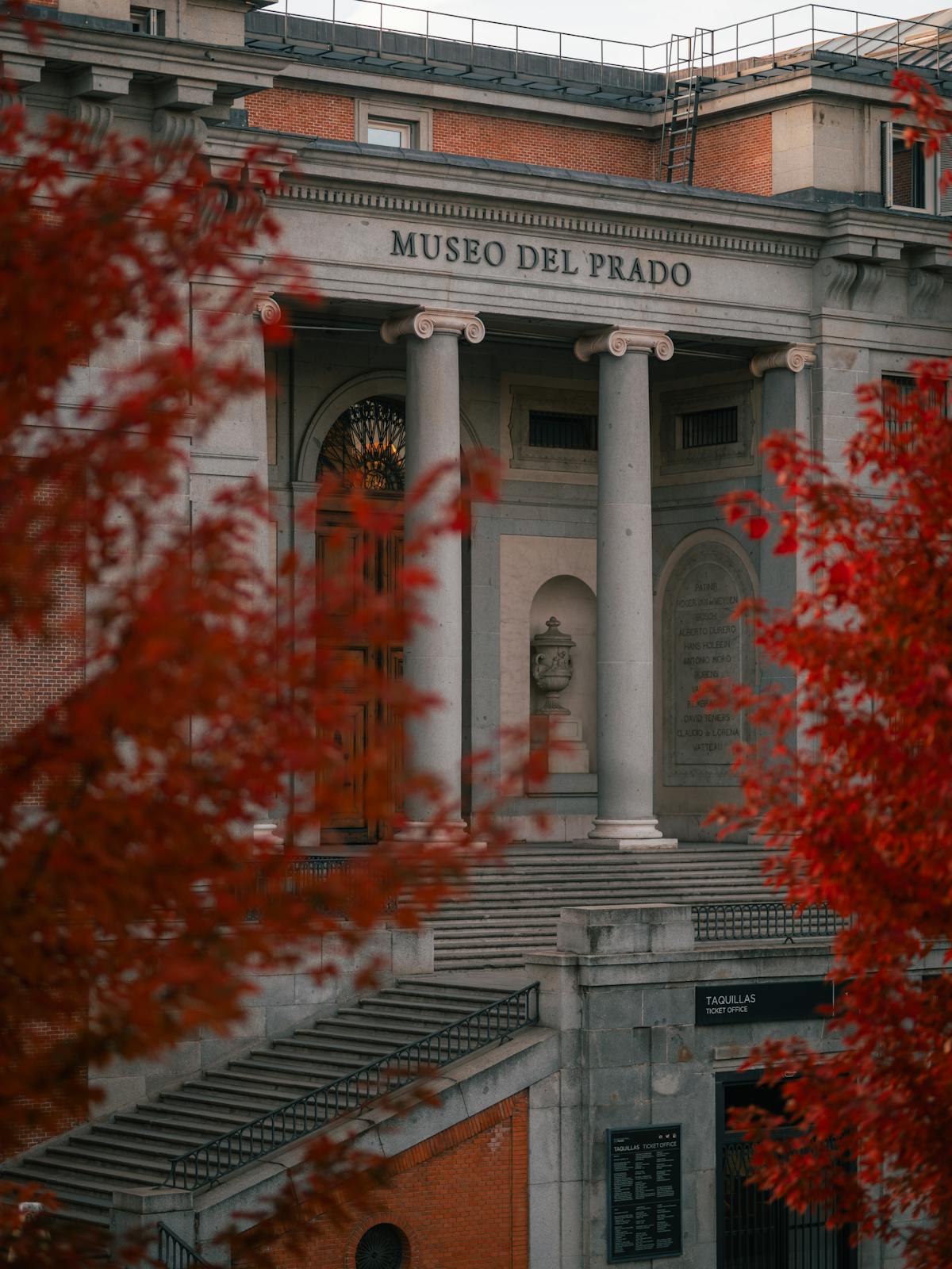 Autumn view of the Museo del Prado in Madrid framed by red leaves