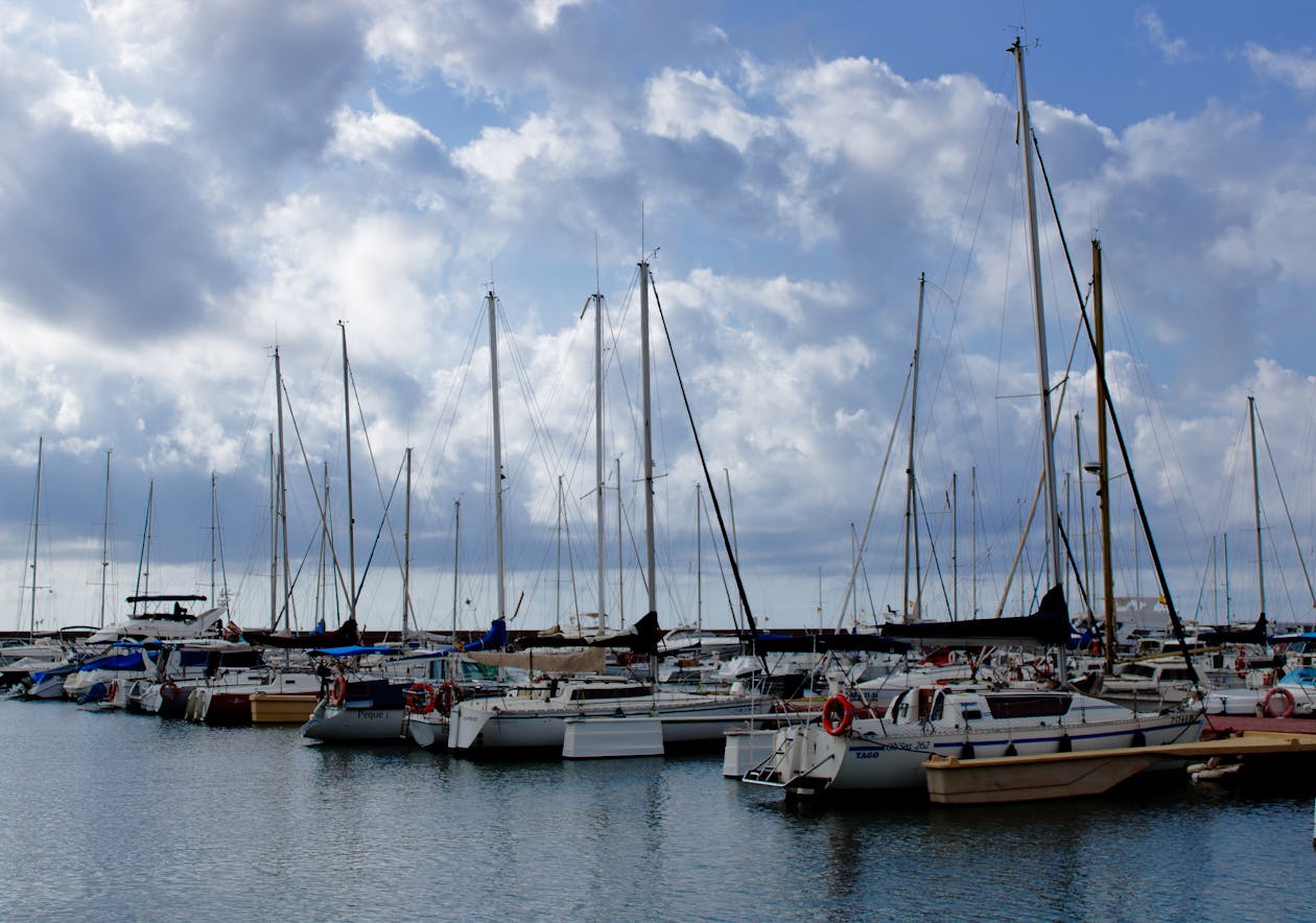 Sailboats lined up at Valencia marina with masts reflecting in the still harbour water