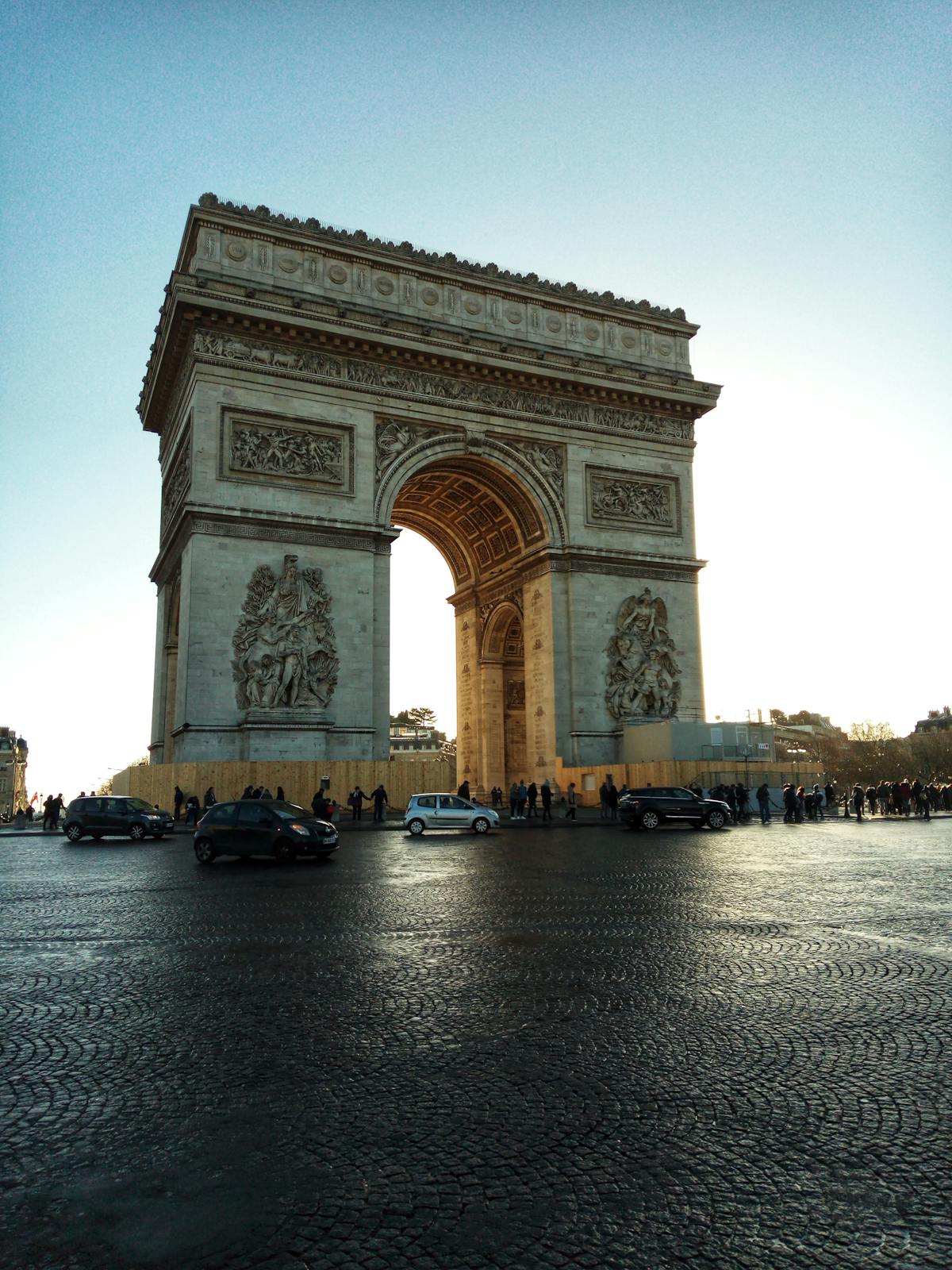 The Arc de Triomphe with street life and a clear blue sky