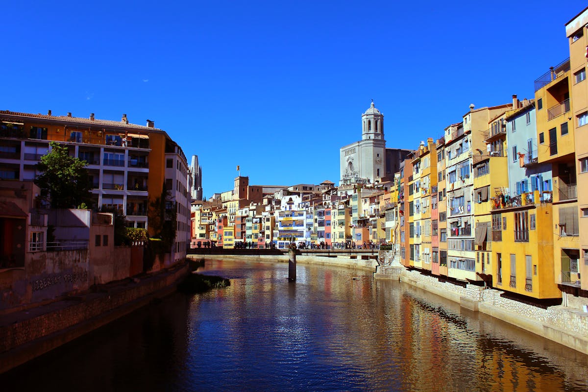 Girona iconic colourful houses along the Onyar River under blue sky