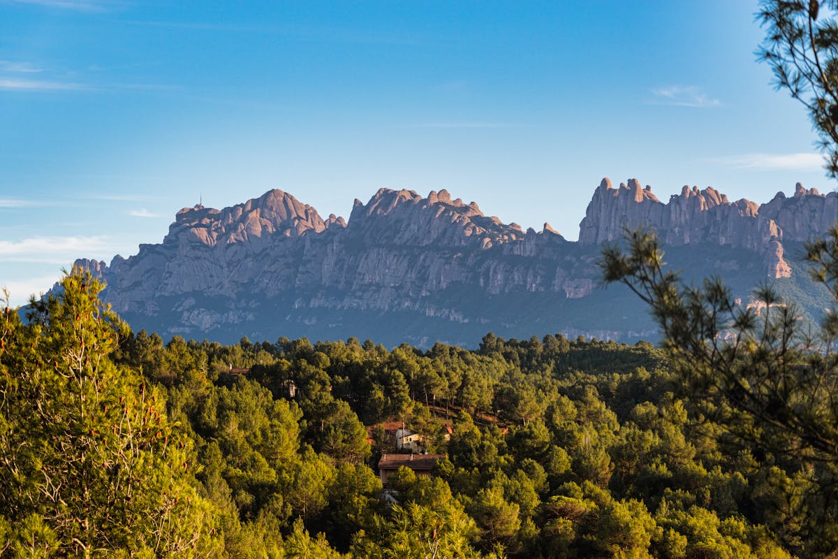 Aerial view of Montserrat serrated mountain peaks and the green valley below