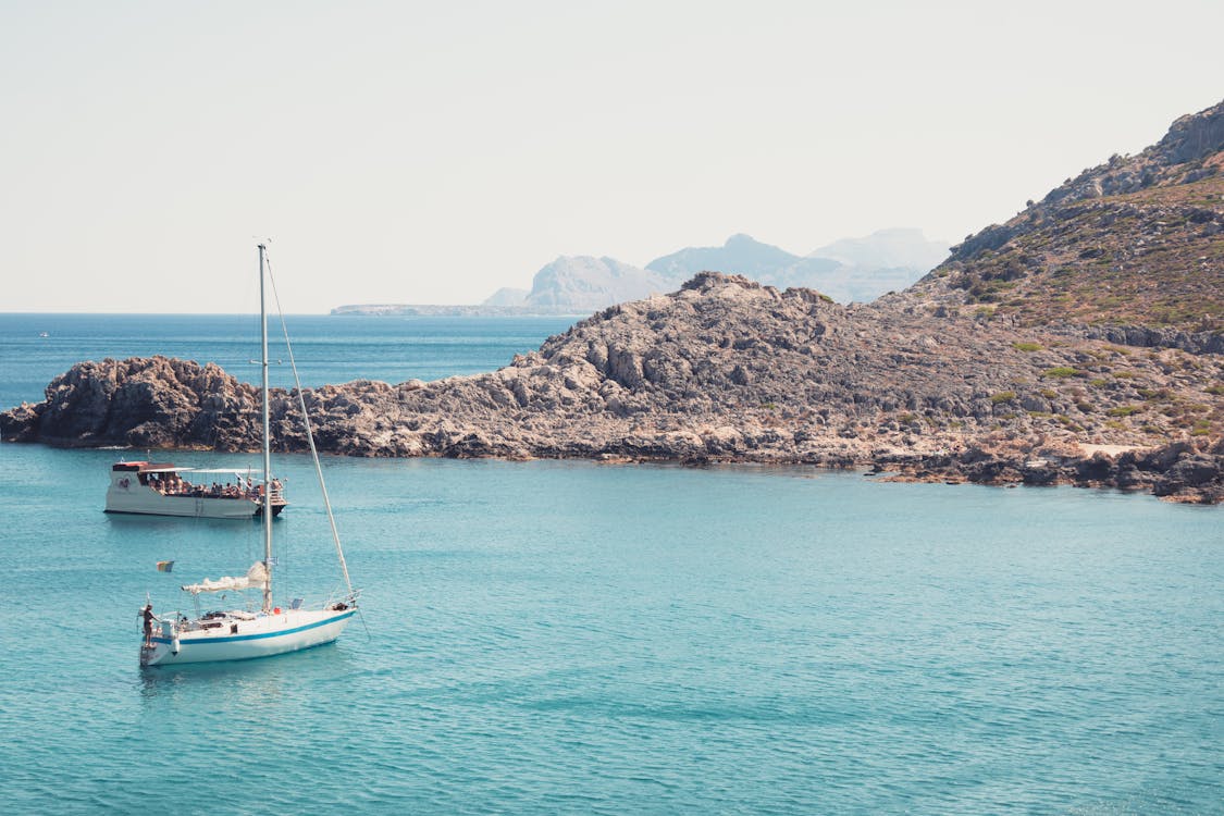 Boats near rocky shoreline in Rhodes Greece