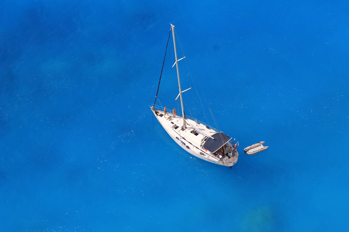 Aerial view of sailboat on turquoise water near Greek coast