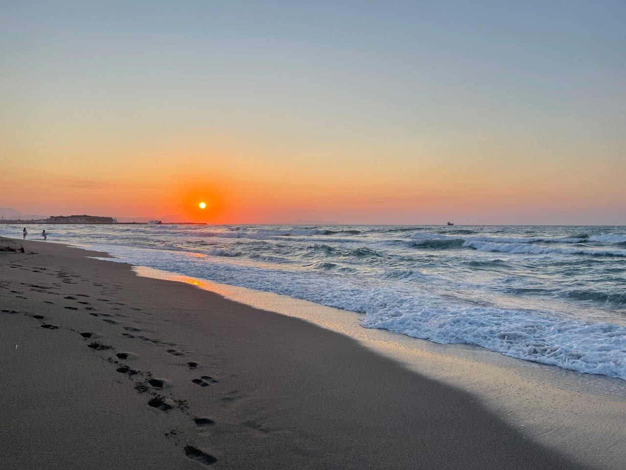 A beach sunset in Rethimno Crete with footprints in the sand