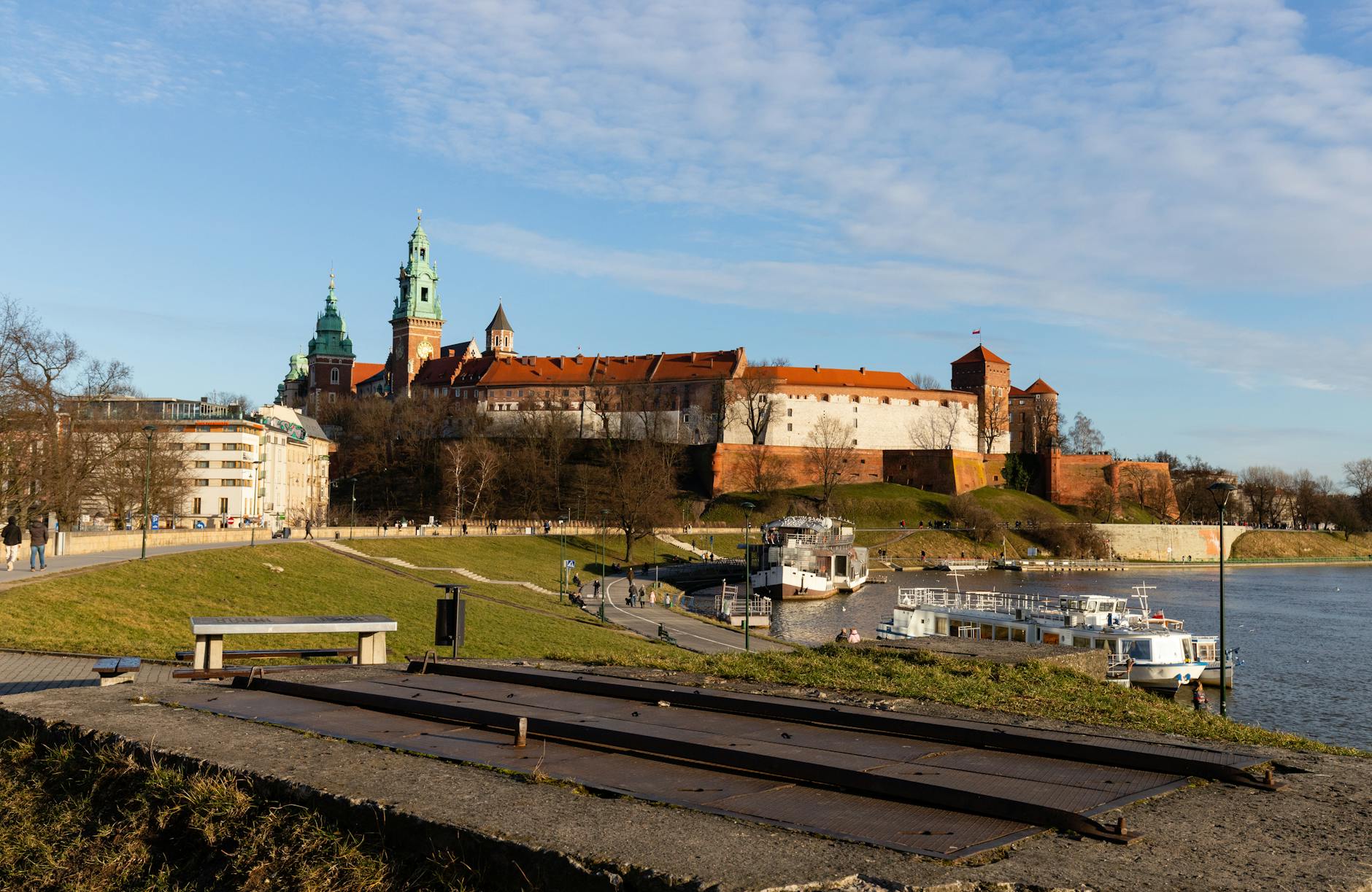 Wawel Castle and the Vistula River in Krakow on a sunny day with lush greenery