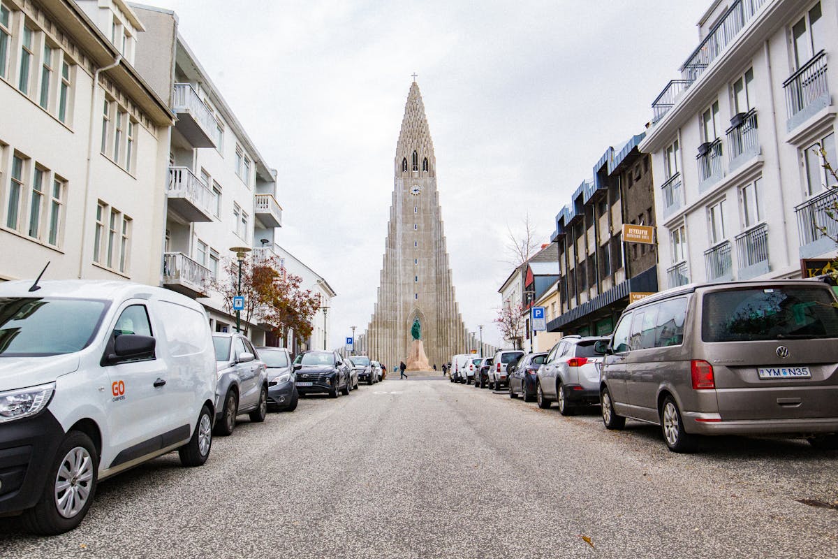 Street leading to Hallgrimskirkja church in Reykjavik with parked cars