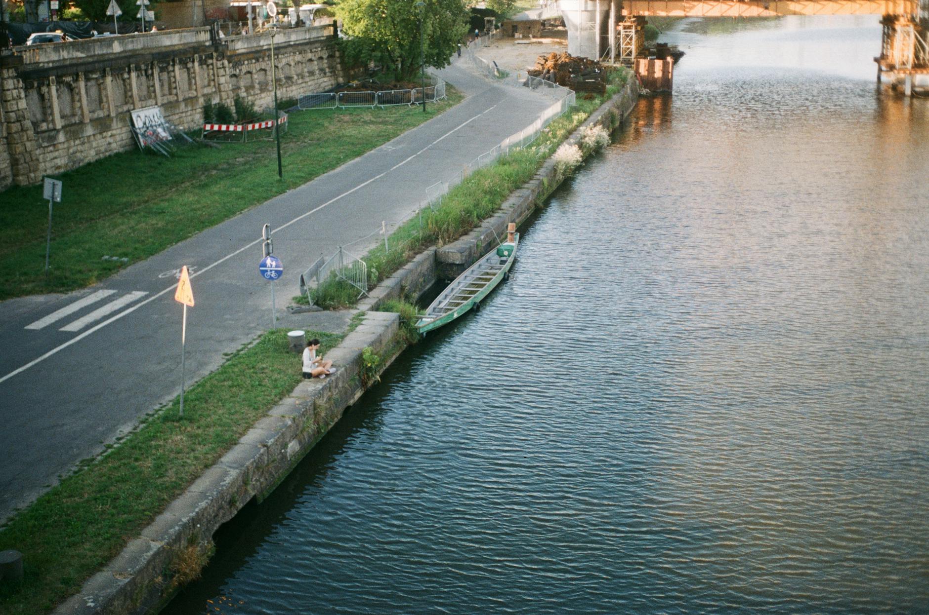Aerial view of the Vistula riverfront in Krakow showing a lone boat and walking paths