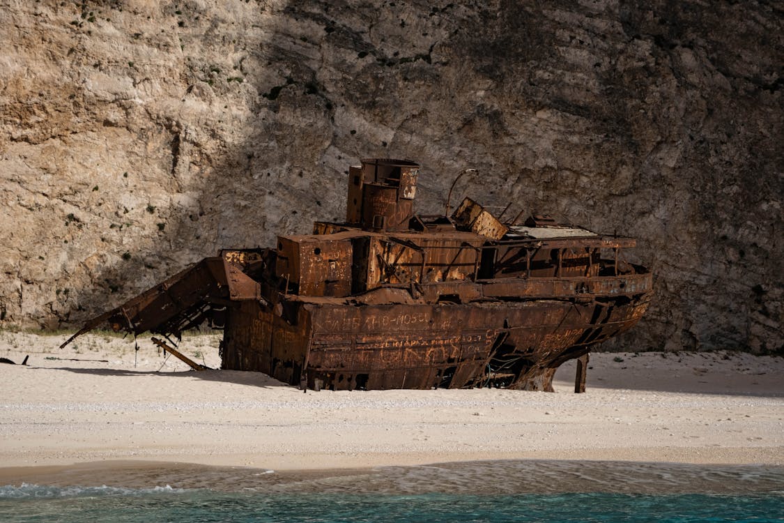 The weathered shipwreck at Navagio Beach surrounded by white sand and limestone cliffs