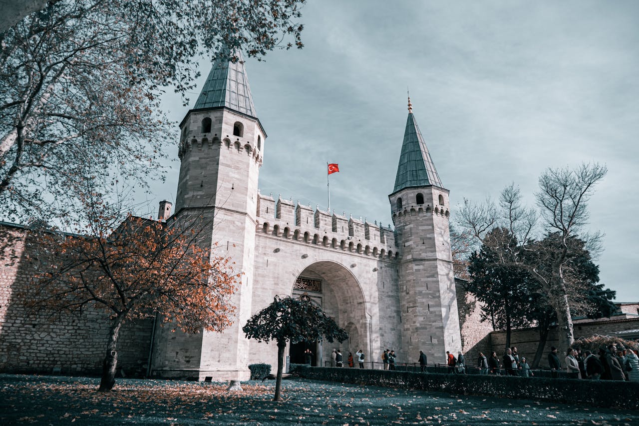 Historic entrance of Topkapi Palace during autumn with golden foliage