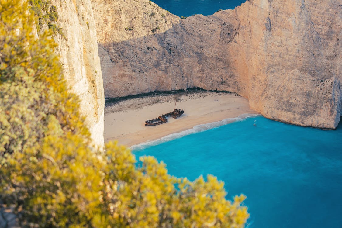 Classic viewpoint shot of Navagio Beach from the cliffs above showing the cove and turquoise water