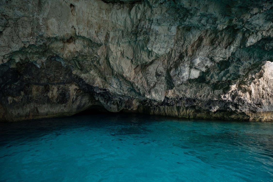 View from inside a Blue Cave looking out at turquoise water and rocky walls