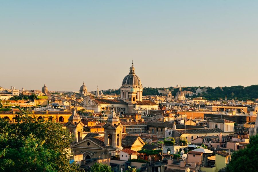 Rome skyline at sunset showing historic domes and ancient buildings in warm light