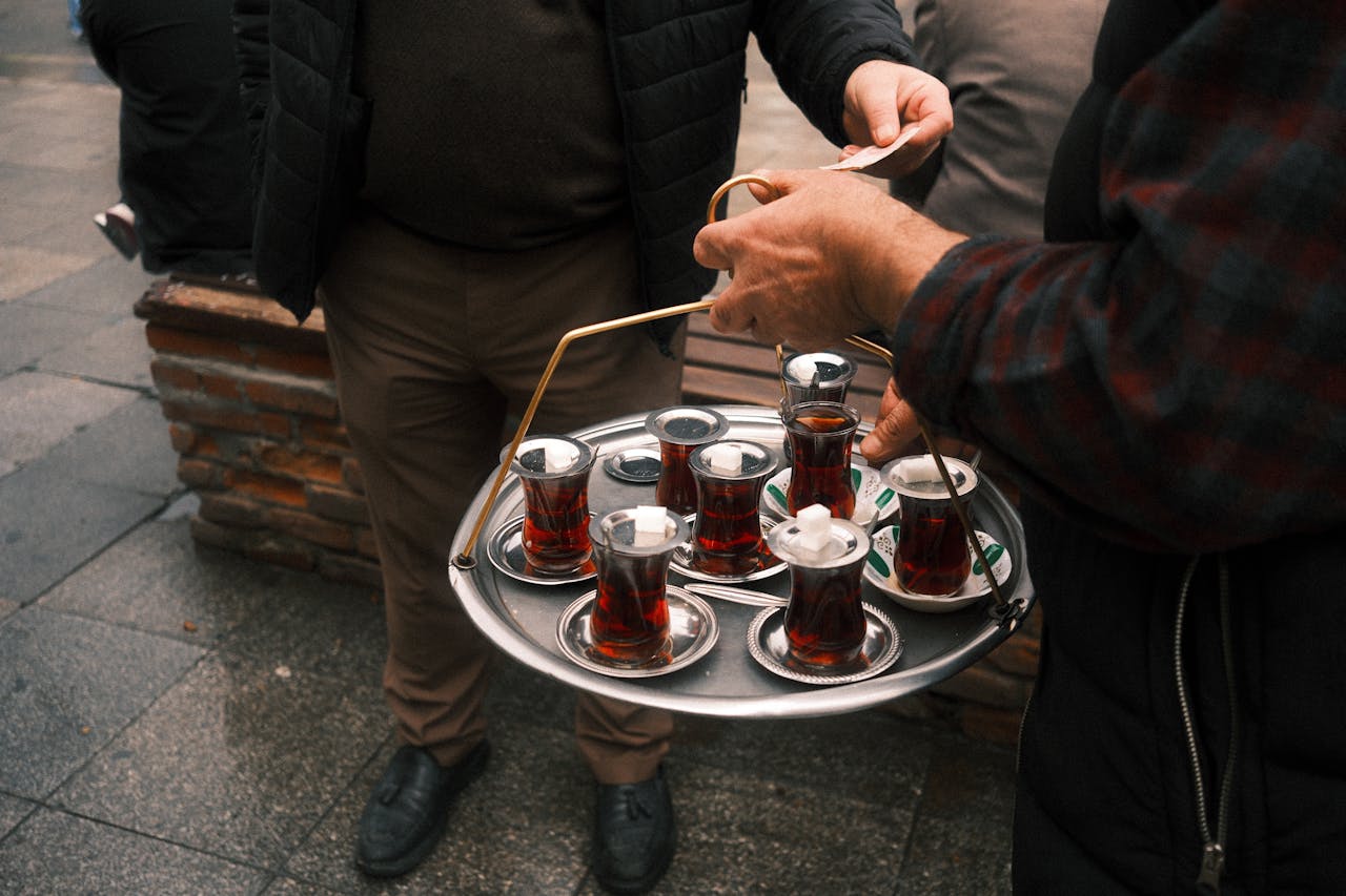 Street vendor serving traditional Turkish tea in tulip glasses in Istanbul
