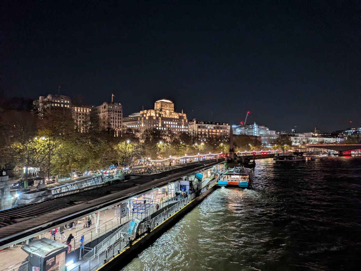 London riverside buildings and architecture illuminated at night with reflections on the Thames