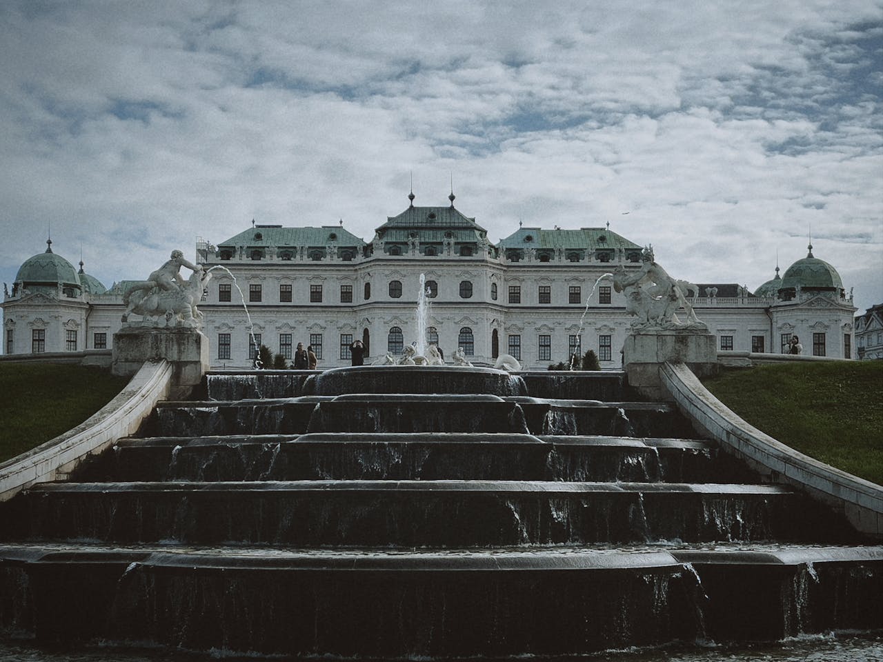 Belvedere Palace with cascading fountains under dramatic sky in Vienna