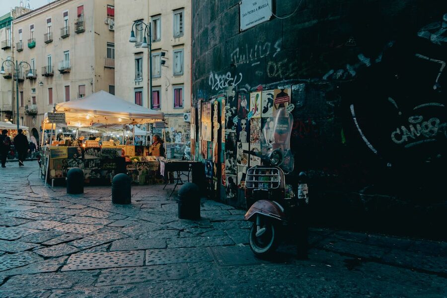Busy evening street market in historic Naples with food stalls and pedestrians