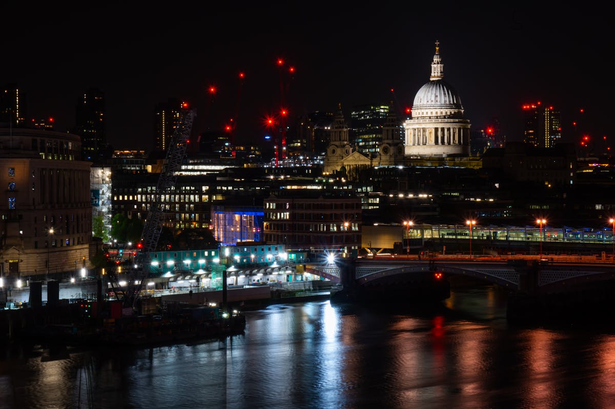 St Pauls Cathedral dome illuminated at night with London city lights reflecting on the River Thames