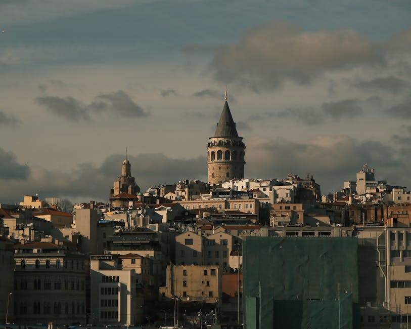 Galata Tower against Istanbul's skyline under cloudy sky