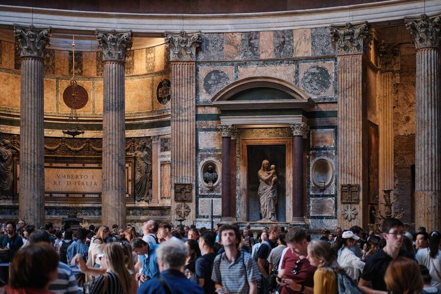 Crowds of visitors inside the Pantheon in Rome showing the massive columns and interior sculptures