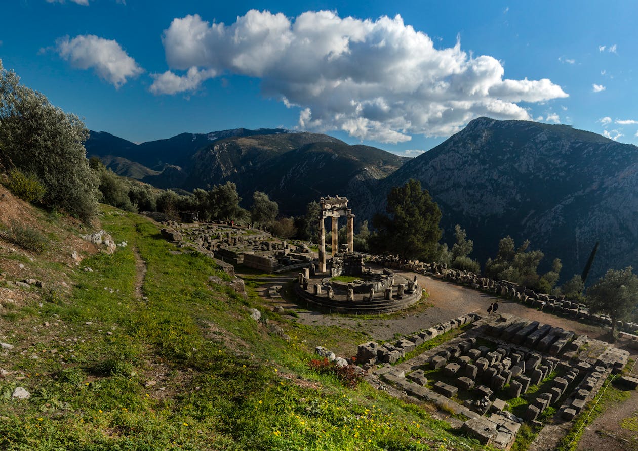 Ancient Delphi ruins set against mountains under blue sky