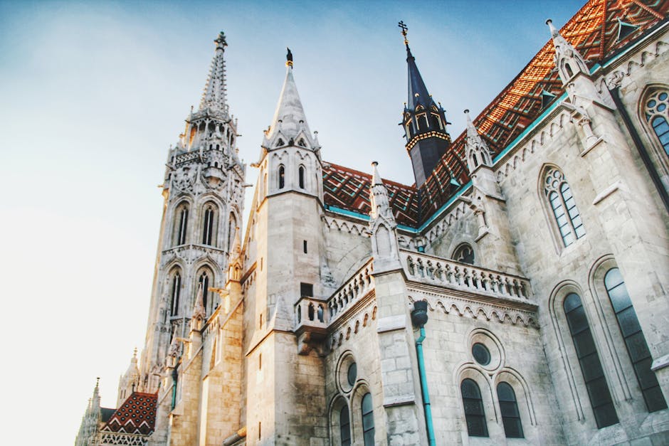 Low angle view of Matthias Church showing Gothic stone architecture against blue sky in Budapest