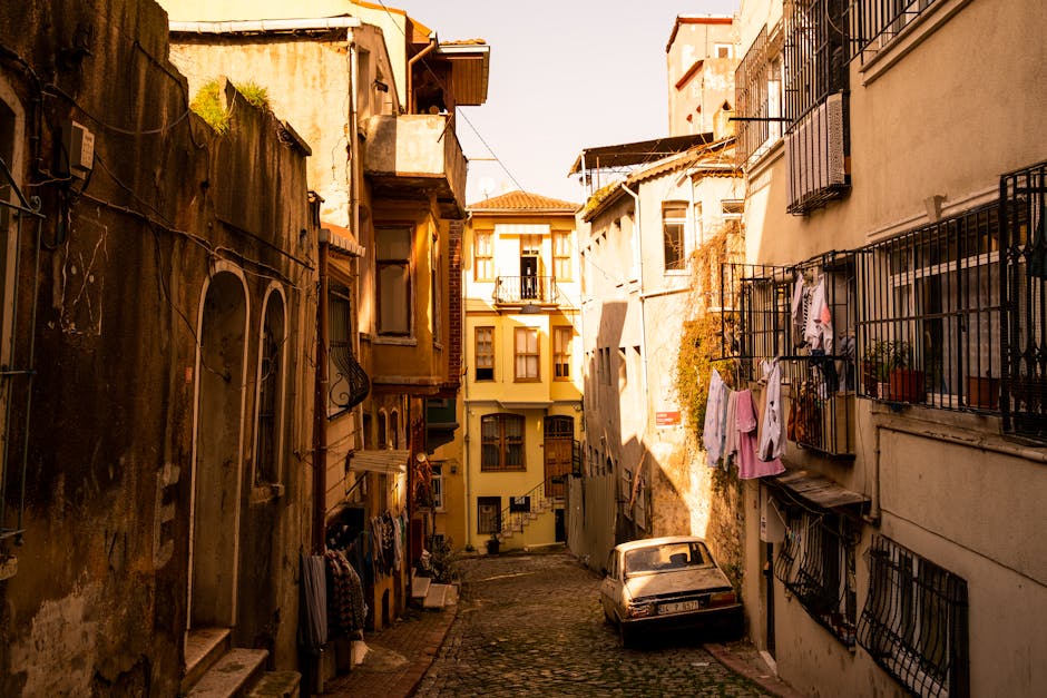 Narrow cobblestone street in Istanbul's historic district with sunlight filtering through old buildings