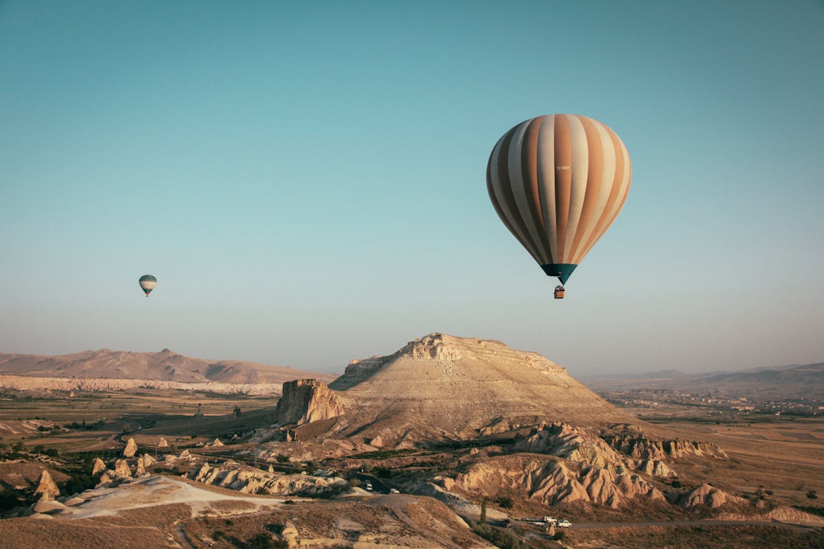 Colorful hot air balloons floating over Cappadocia fairy chimneys at sunrise