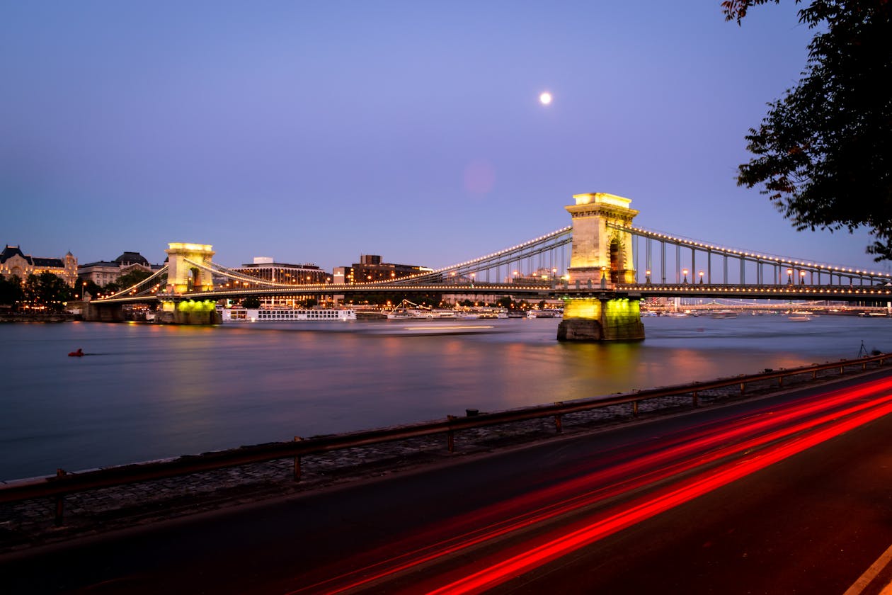Szechenyi Chain Bridge at night with moonlight and car light trails over the Danube River Budapest