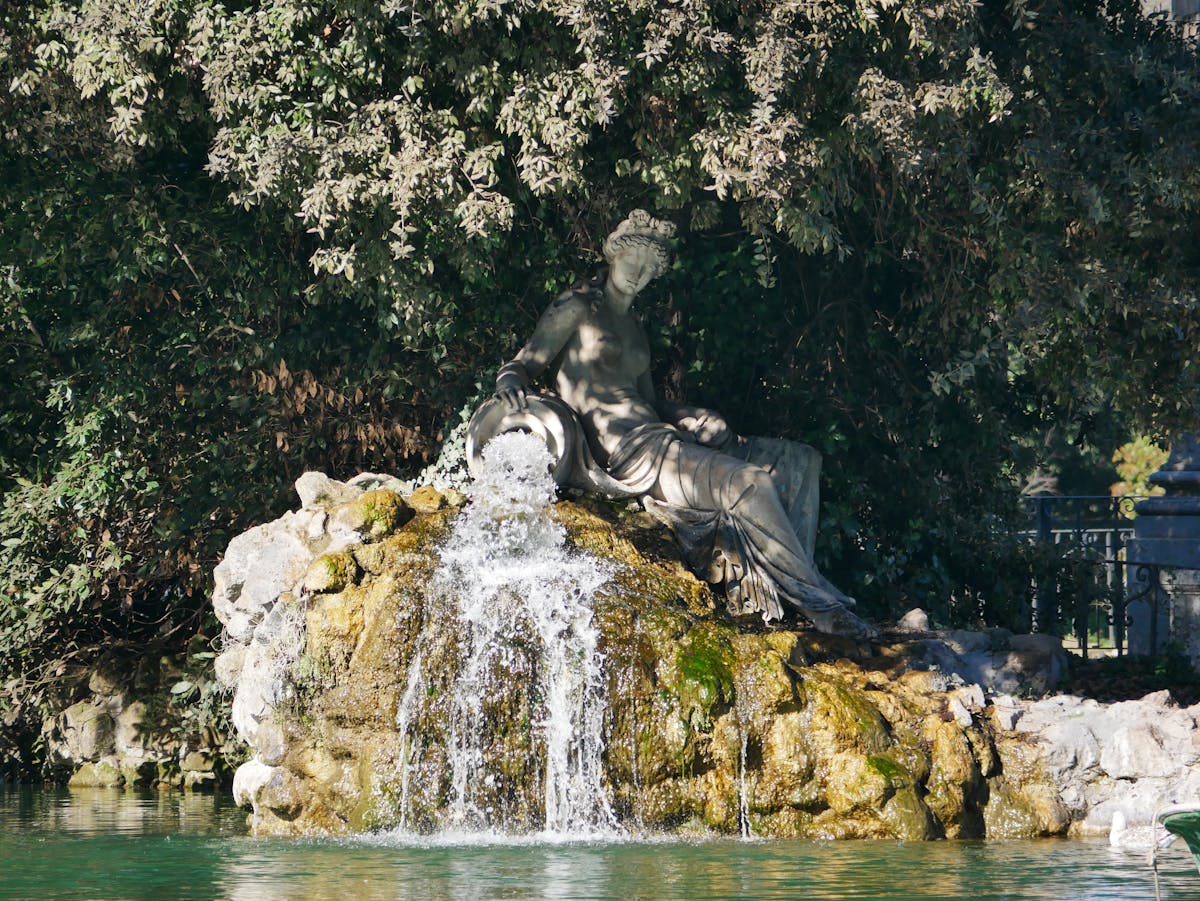 Sculptural fountain with cascading water in Villa Borghese park Rome