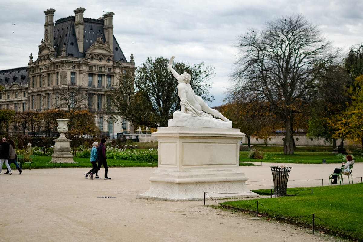 Classic sculpture in a Parisian garden with historic architecture behind