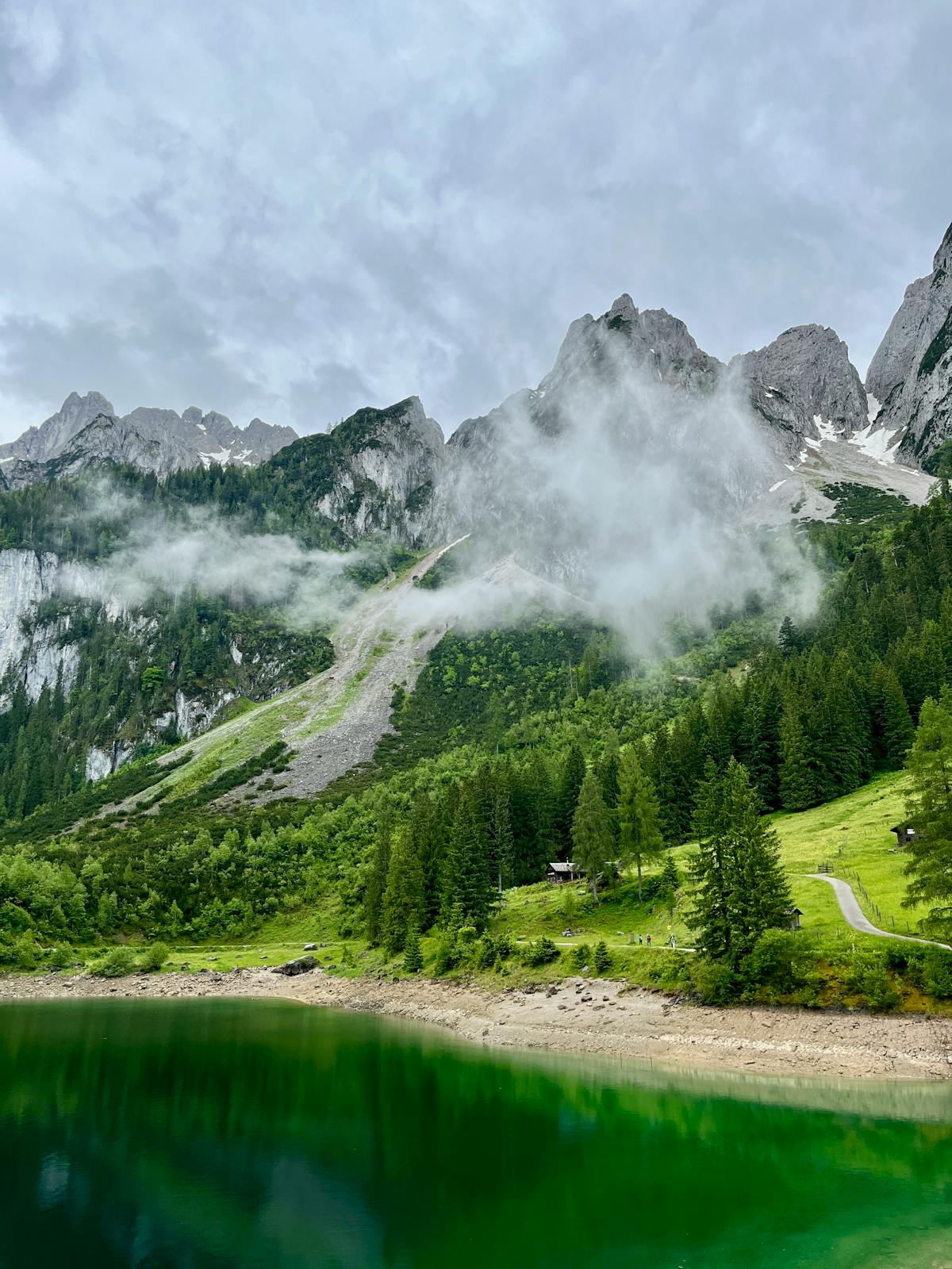 Dramatic misty mountains over Gosausee lake in Upper Austria