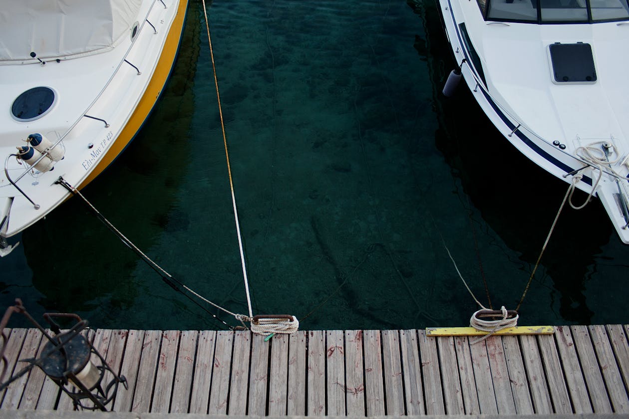 Aerial view of boats docked on crystal-clear turquoise water at a Greek island