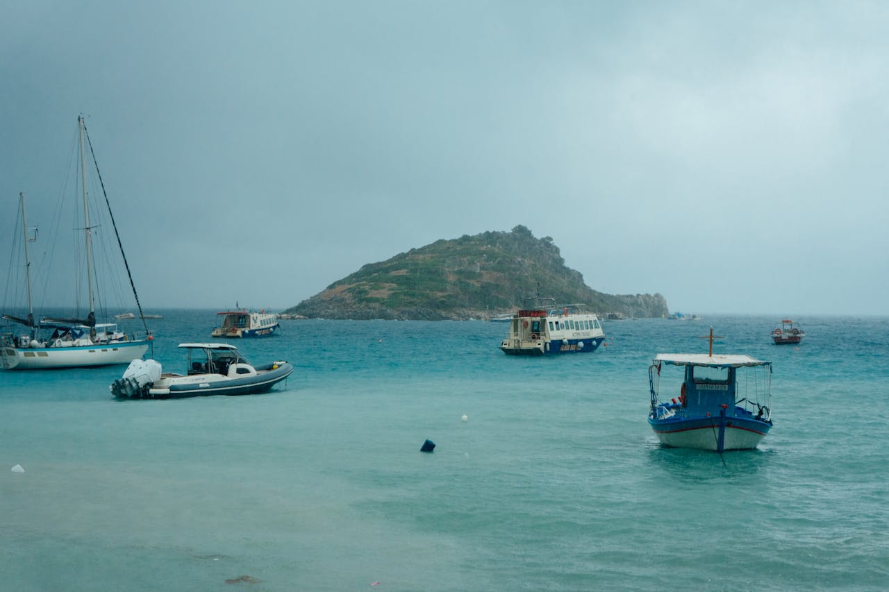 Boats anchored in turquoise waters near a Greek island