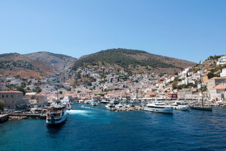 Panoramic view of Hydra harbor with traditional stone buildings rising from the waterfront