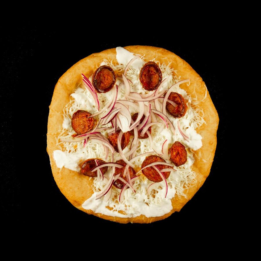 Traditional Hungarian langos fried bread with toppings from a Budapest street vendor