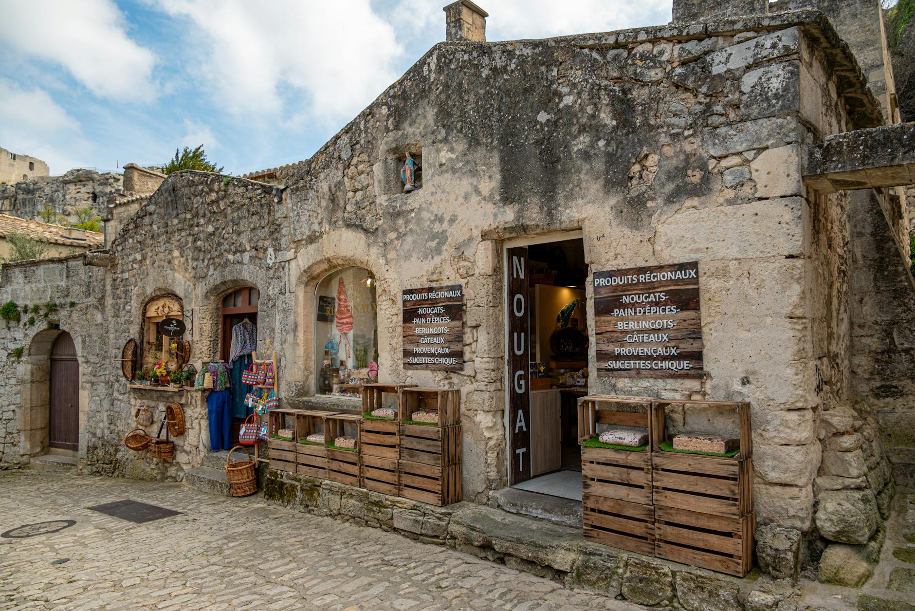 Rustic stone shop front in Les Baux-de-Provence displaying local products from Provence